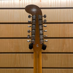 Close-up of a guitar headstock with tuning pegs against a wooden background